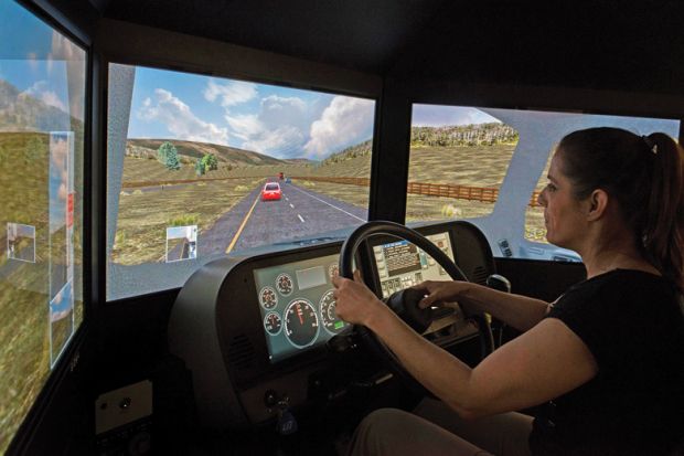 Woman using simulator to drive Woman using simulator to drive