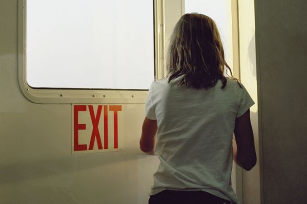 Woman walking through door marked 'Exit'