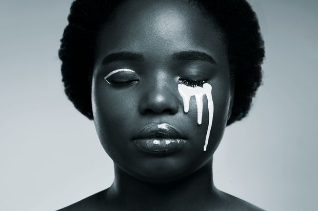 Black woman with white paint on her face to illustrate issue of diversity
