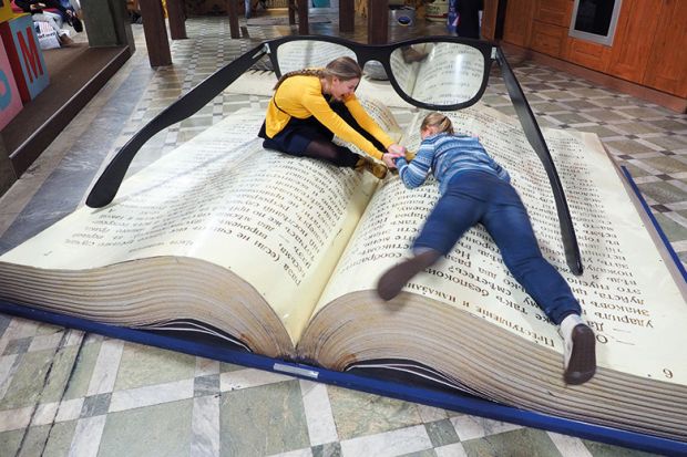 Women lying on giant book
