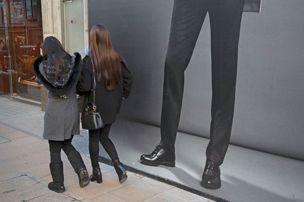 Women walking past mans legs