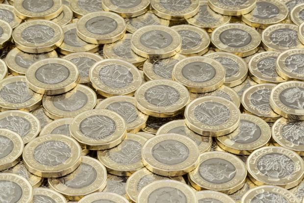 Wrexham, UK - April 10, 2017 Hoard of money. Lots of coins scattered in a large pile. New British pound coins introduced in 2017