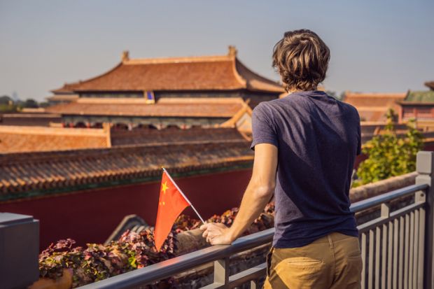 Young man with national chinese flag in Forbidden City