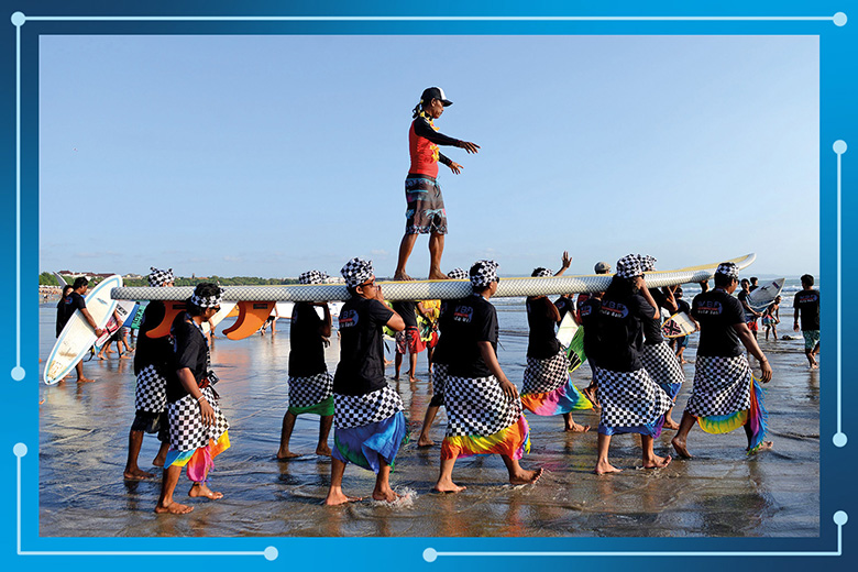 A surfer stands on giant surf board carried on the beach after breaking the Indonesia World Records Museum (MURI) for the largest surfboard in Asia. To illustrate the Asean region lifting itself up in the World University Rankings. A surfer stands on giant surf board carried on the beach after breaking the Indonesia World Records Museum (MURI) for the largest surfboard in Asia. To illustrate the Asean region lifting itself up in the World University Rankings.