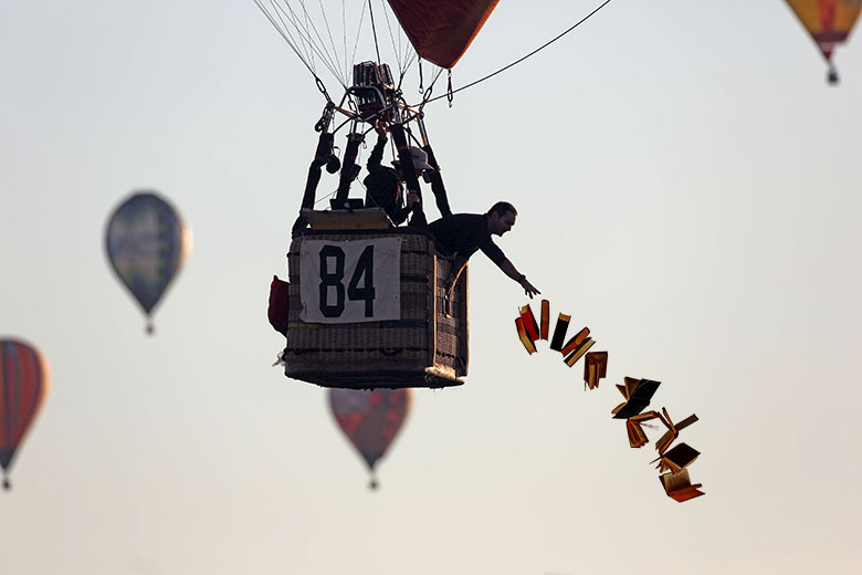 A hot air balloonist dropping books from the basket. To illustrate that the accelerated degree movement in the US has a greater emphasis on cutting “unnecessary” modules.