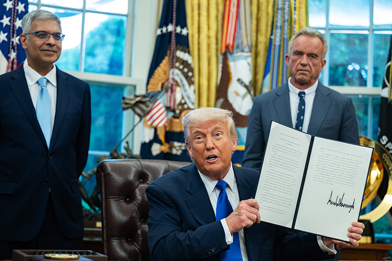 President Donald Trump signs executive orders in the Oval Office of the White House on 5 May 2025 in Washington, DC. The orders were primarily healthcare related. With director of NIH Jay Bhattacharya (L) and Robert F. Kennedy Jr (R).
