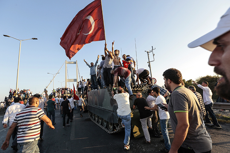 Supporters of Turkish president Recep Tayyip Erdoğan wave flags as they capture a Turkish Army APC after soldiers involved in the coup attempt have surrendered on Istanbul’s Bosphorus bridge in Istanbul, 16 July 2016, Turkey. Supporters of Turkish president Recep Tayyip Erdoğan wave flags as they capture a Turkish Army APC after soldiers involved in the coup attempt have surrendered on Istanbul’s Bosphorus bridge in Istanbul, 16 July 2016, Turkey.