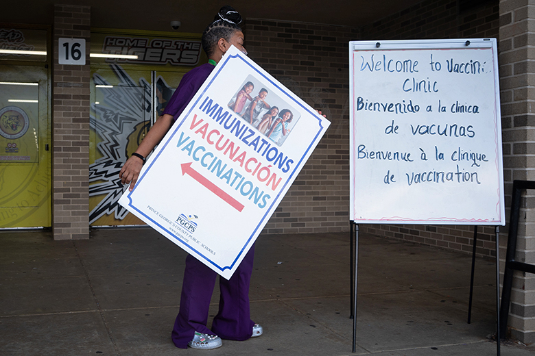 A health specialist takes the sign down at the end of a vaccine clinic at a school in Bowie, MD on 13 August 2025. Parents are weighing up mixed messages coming from the Trump administration about vaccine recommendations.