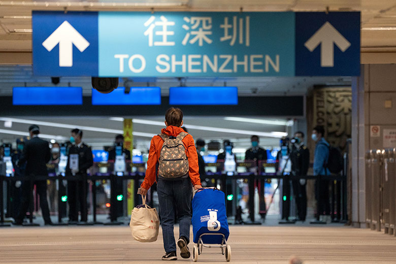 A traveller walks towards Shenzhen in the border control area at MTR Corp. Lo Wu station in Hong Kong, China. A traveller walks towards Shenzhen in the border control area at MTR Corp. Lo Wu station in Hong Kong, China.