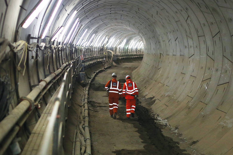 Workers walking through Crossrail tunnel, London