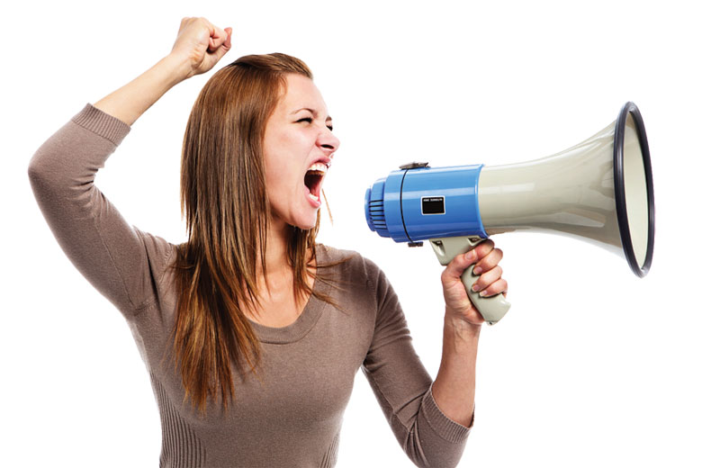 Young woman shouting through megaphone