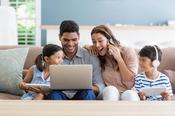 Young family looking at laptop