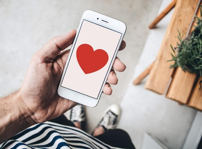 Man holding phone with heart on the screen