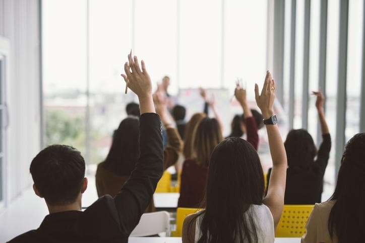 Students raising hand in classroom