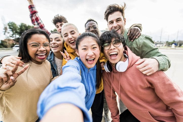 Multiracial friends taking big group selfie shot smiling