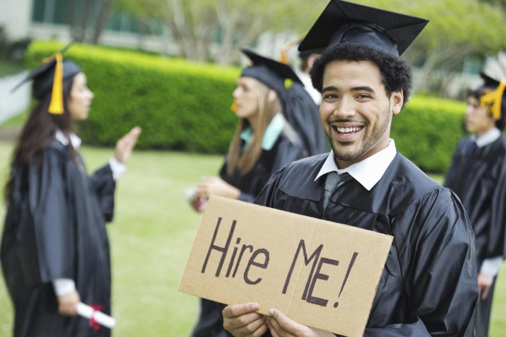 Graduate holding hire me sign