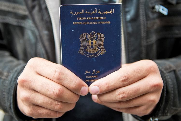 Man holds Syrian passport, Luebeck, Germany, 2015