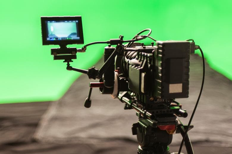 Video camera filming against green screen backdrop