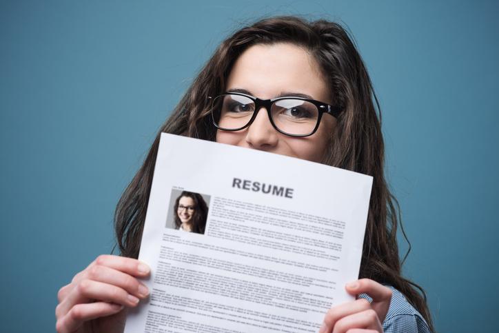 Young woman holding her resume / iStock
