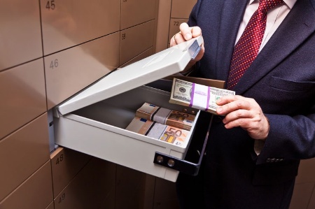 Man putting cash into bank vault locker