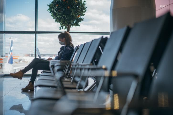 Woman sitting in airport with mask on
